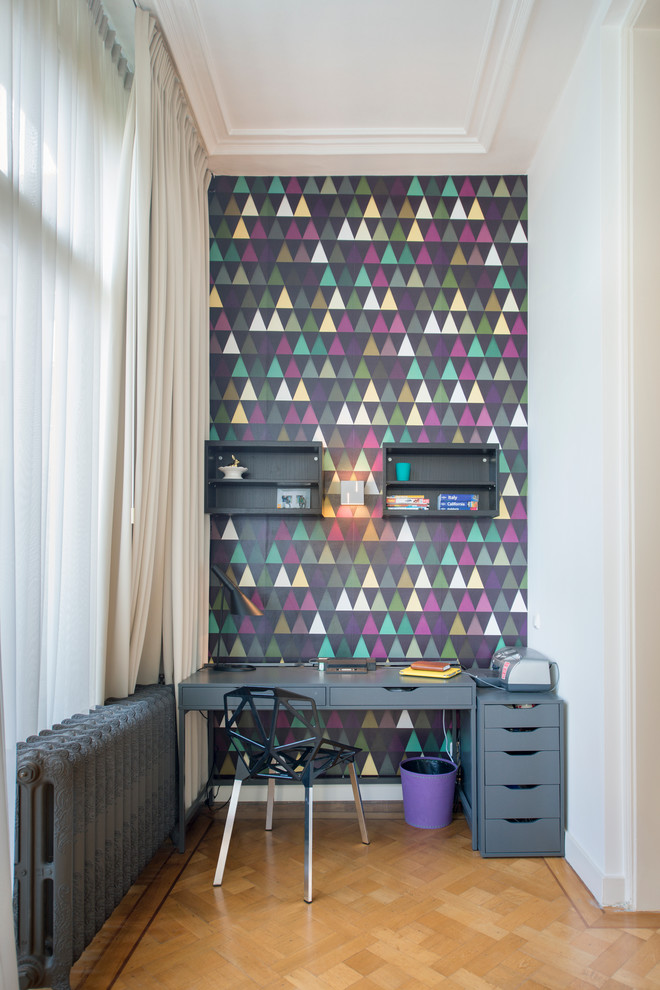 Foto de despacho contemporáneo pequeño con paredes multicolor, suelo de madera clara y escritorio independiente