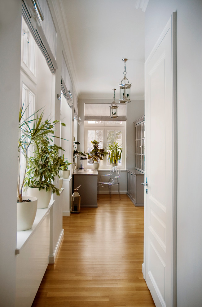 Example of a classic medium tone wood floor home office design in Other with gray walls