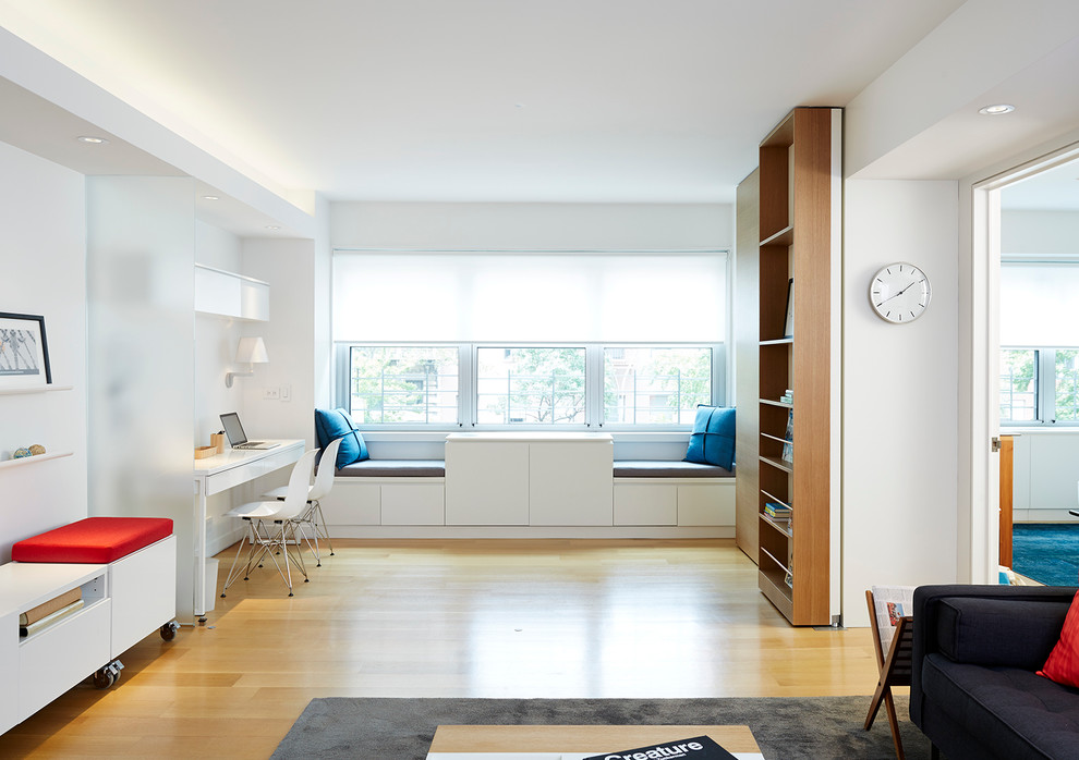 Modelo de estudio moderno de tamaño medio con paredes blancas, suelo de madera en tonos medios y escritorio independiente