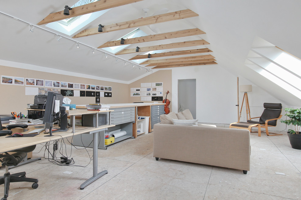 Modern inredning av ett stort hemmastudio, med vita väggar, plywoodgolv och ett fristående skrivbord