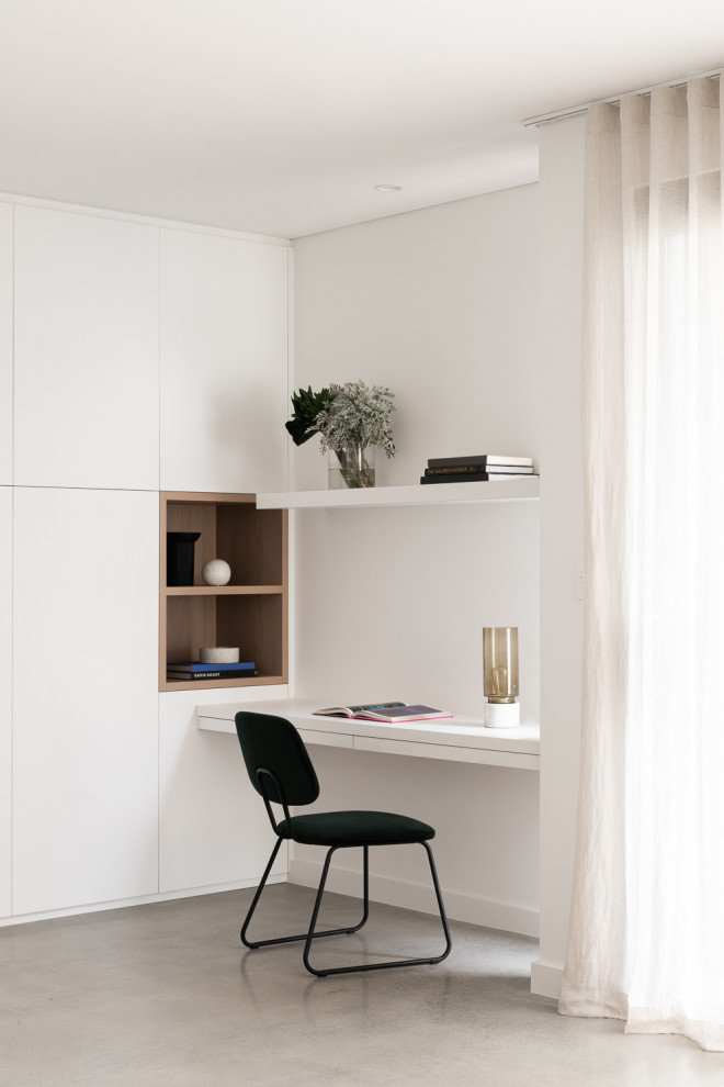 Idee per un grande studio minimalista con pavimento in cemento, pavimento grigio, pareti bianche e scrivania incassata