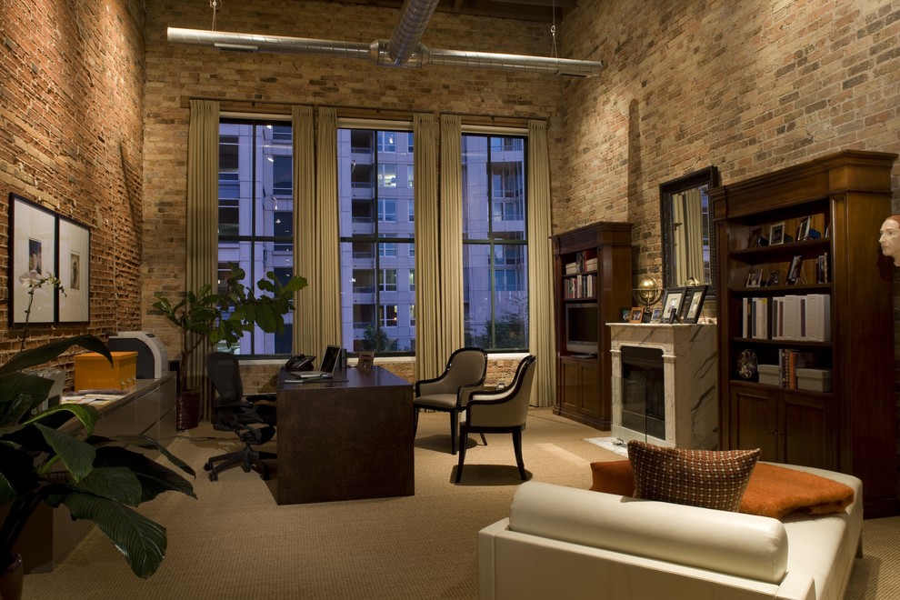 シカゴにある高級な広いインダストリアルスタイルのおしゃれな書斎 (カーペット敷き、標準型暖炉、石材の暖炉まわり、自立型机、マルチカラーの壁) の写真
