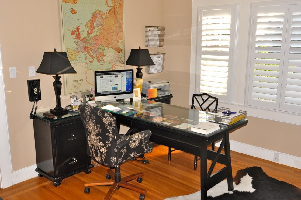 Exempel på ett modernt arbetsrum, med beige väggar, mellanmörkt trägolv och ett fristående skrivbord