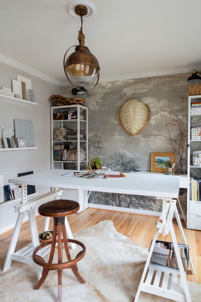 Mittelgroßes Stilmix Arbeitszimmer ohne Kamin mit Studio, grauer Wandfarbe, hellem Holzboden, freistehendem Schreibtisch, Tapetenwänden und beigem Boden in Austin