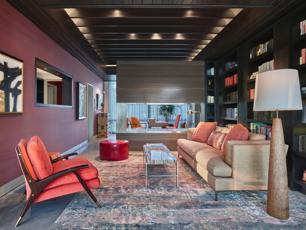 他の地域にある広いコンテンポラリースタイルのおしゃれなホームオフィス・書斎 (赤い壁、コンクリートの床、自立型机、グレーの床) の写真