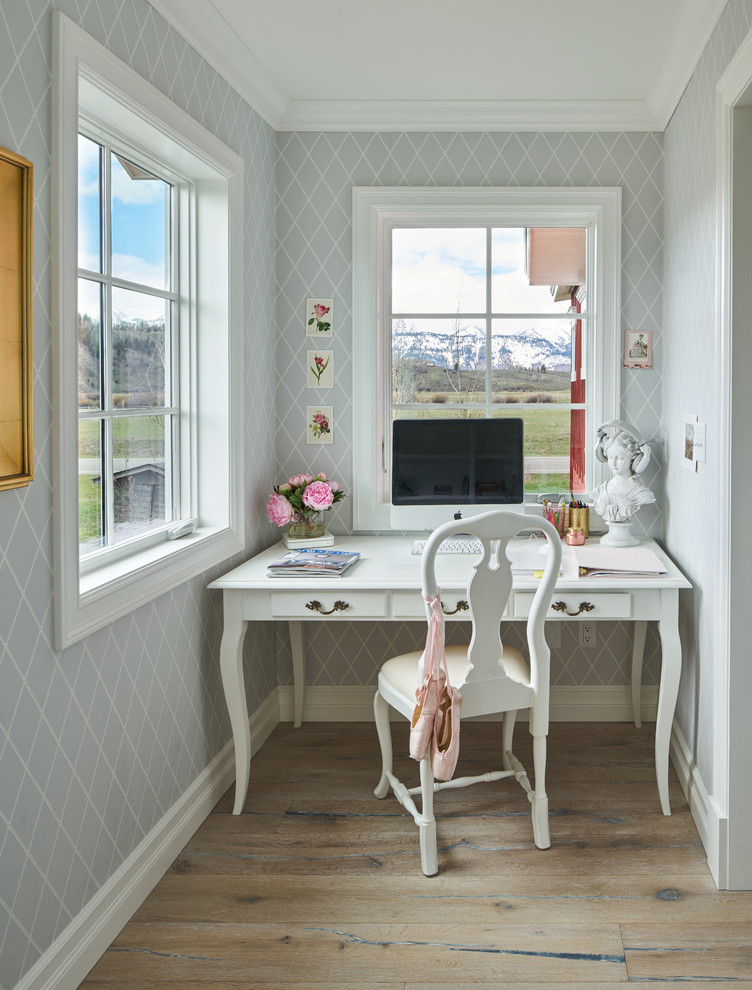 Landhaus Arbeitszimmer mit grauer Wandfarbe, dunklem Holzboden und freistehendem Schreibtisch in Sonstige