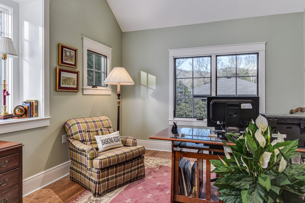 Ejemplo de despacho clásico pequeño con paredes verdes, suelo de madera en tonos medios y escritorio independiente
