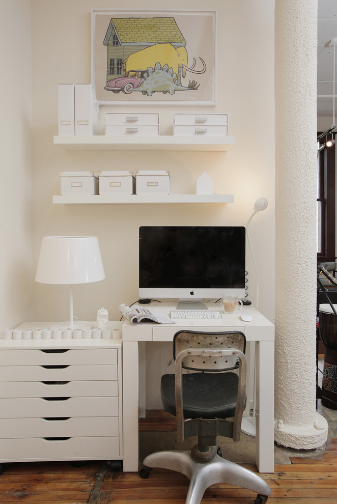 Eclectic freestanding desk medium tone wood floor and brown floor home office photo in Dallas with beige walls
