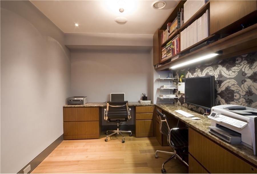 Diseño de despacho moderno de tamaño medio sin chimenea con paredes grises, suelo de madera clara, escritorio empotrado y suelo beige