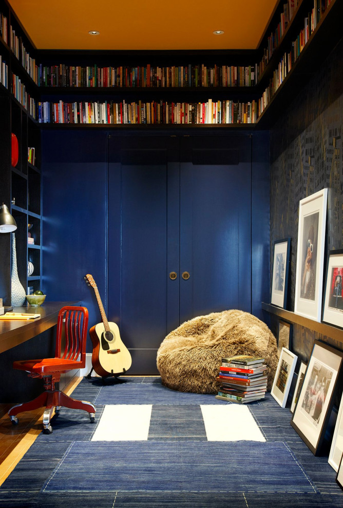Cette photo montre un bureau chic avec un mur bleu, un sol en bois brun, aucune cheminée, un bureau intégré et un sol marron.