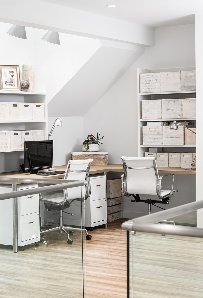 Ejemplo de despacho contemporáneo con paredes blancas, suelo de madera clara, escritorio empotrado y suelo beige