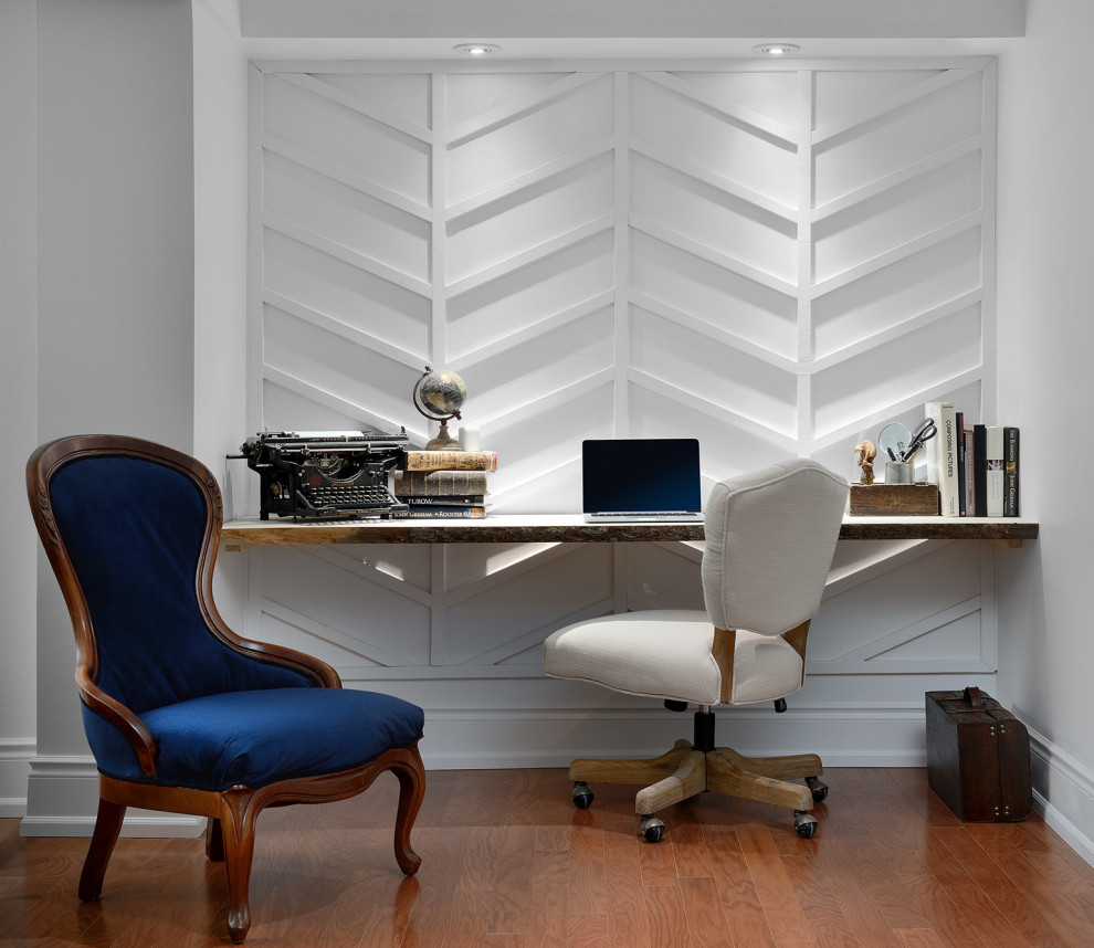 Cette image montre un petit bureau style shabby chic en bois avec un mur blanc, un sol en bois brun, un bureau intégré et un sol marron.
