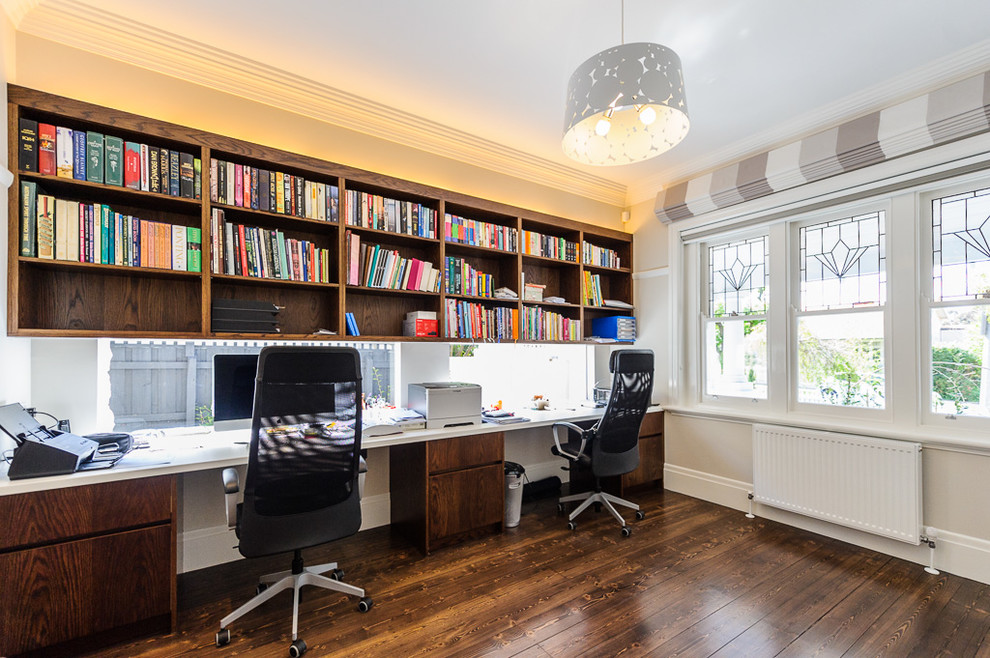 Imagen de despacho minimalista grande con paredes grises, suelo de madera oscura, escritorio empotrado y suelo marrón