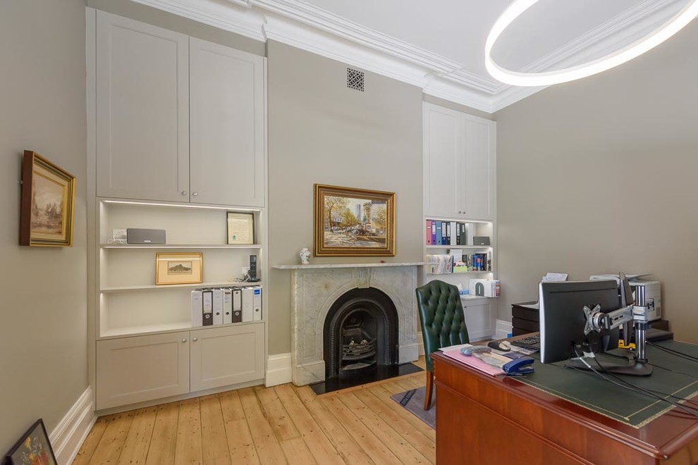 Aménagement d'un petit bureau classique avec un mur gris, parquet clair, une cheminée standard et un manteau de cheminée en pierre.