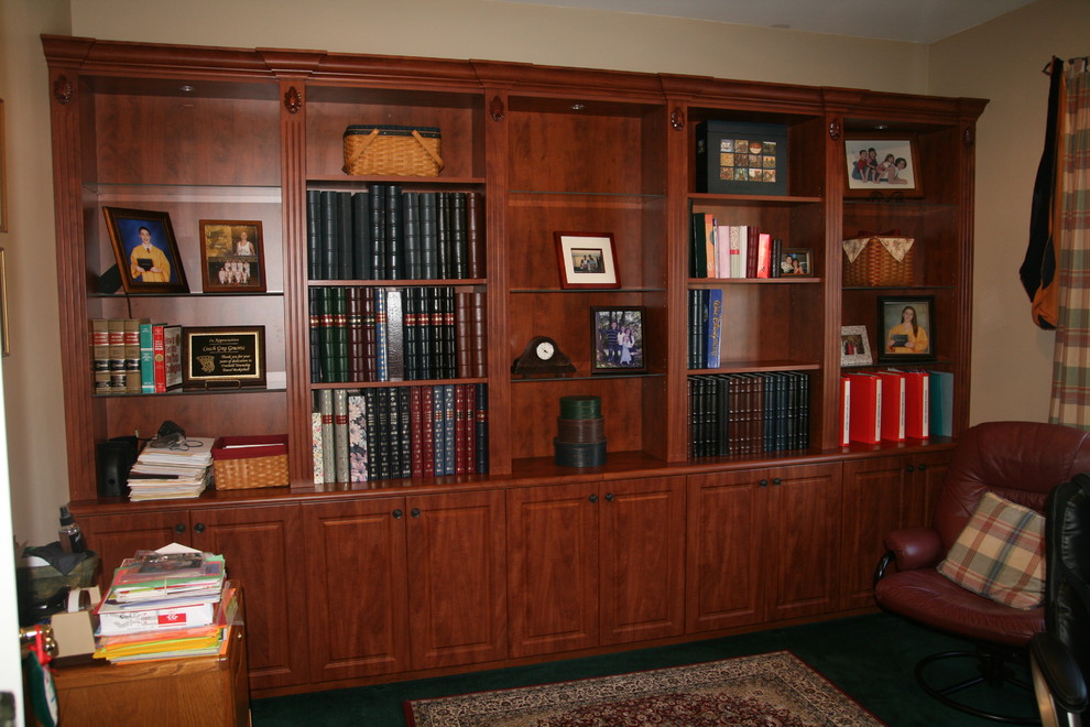 Foto på ett mellanstort vintage hemmabibliotek, med beige väggar, mörkt trägolv, ett fristående skrivbord och brunt golv