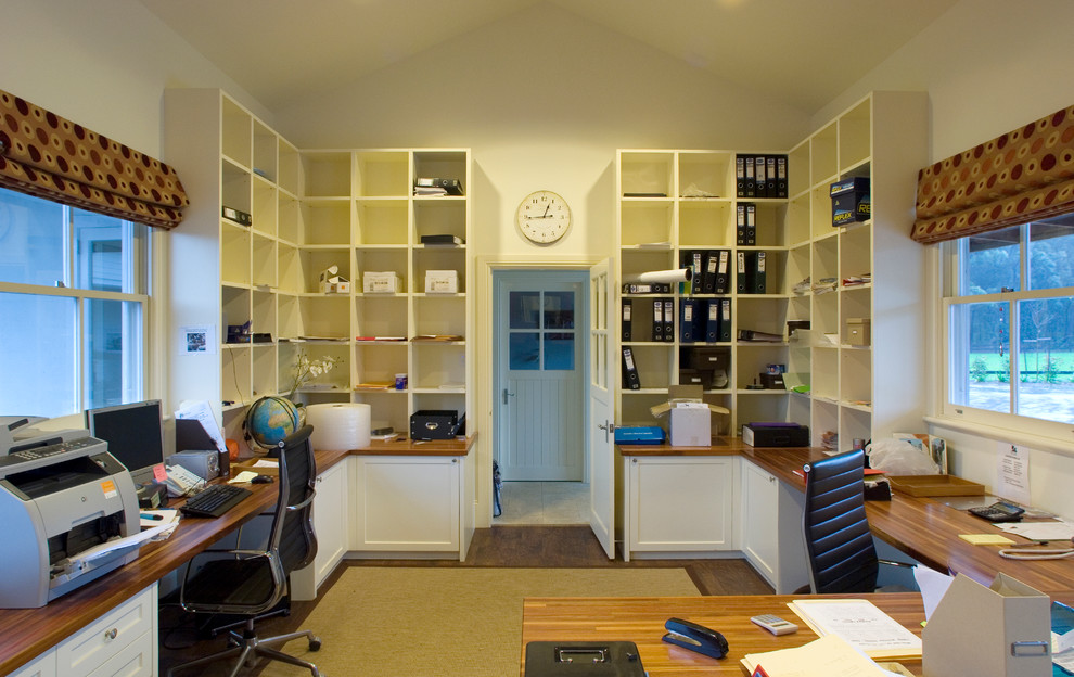 Ejemplo de despacho rústico de tamaño medio sin chimenea con escritorio empotrado, paredes blancas y suelo de madera en tonos medios