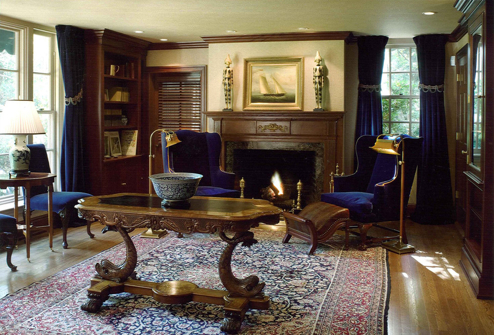 Foto de despacho clásico grande con paredes beige, suelo de madera en tonos medios, todas las chimeneas y escritorio independiente