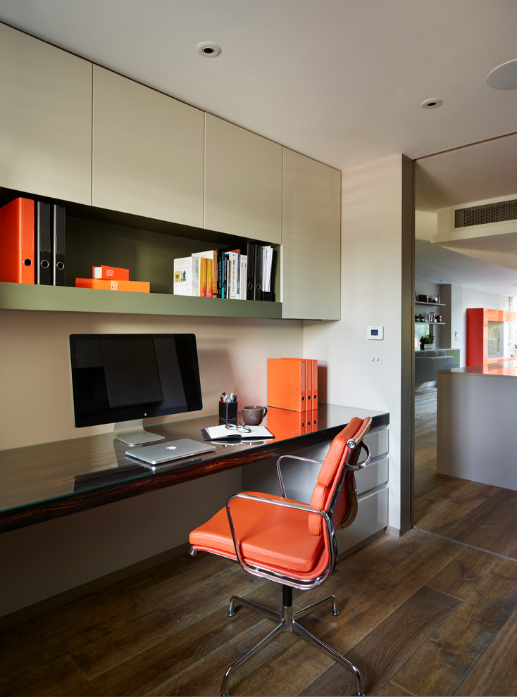Diseño de despacho contemporáneo con escritorio empotrado y suelo de madera oscura