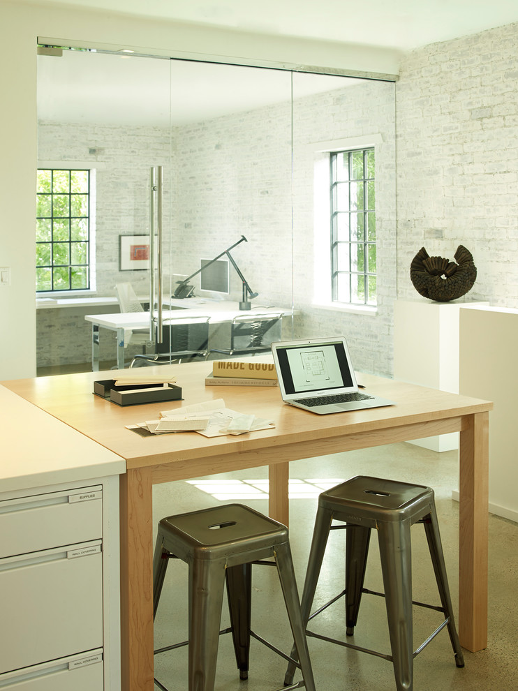Foto di un ampio atelier design con pareti bianche, pavimento in cemento, scrivania autoportante e pavimento beige