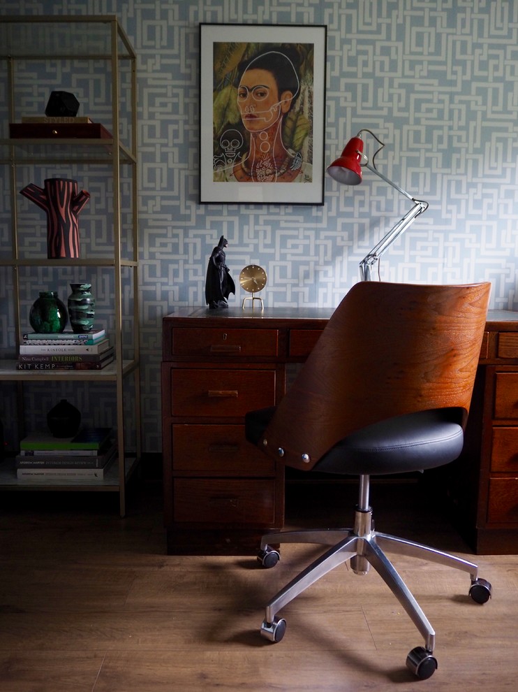 Foto di un piccolo ufficio bohémian con pareti blu, pavimento in laminato, scrivania autoportante e pavimento marrone