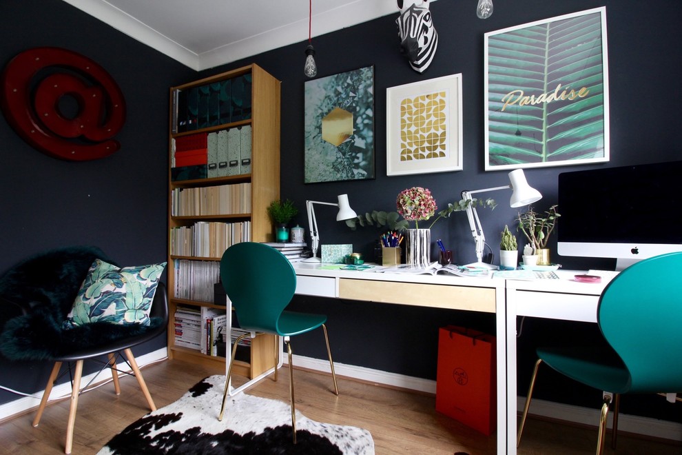 サリーにあるお手頃価格の小さなエクレクティックスタイルのおしゃれな書斎 (黒い壁、ラミネートの床、自立型机、茶色い床) の写真