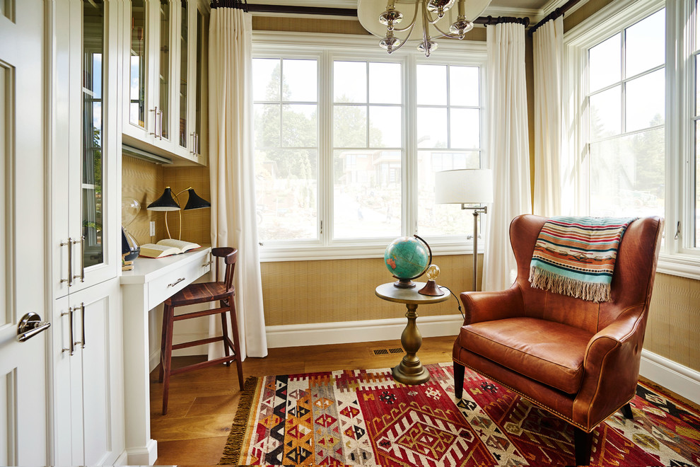 Idee per un piccolo ufficio tradizionale con pareti beige, pavimento in legno massello medio e scrivania incassata