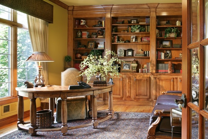 Mittelgroßes Klassisches Arbeitszimmer mit Arbeitsplatz, beiger Wandfarbe, hellem Holzboden und freistehendem Schreibtisch in New York