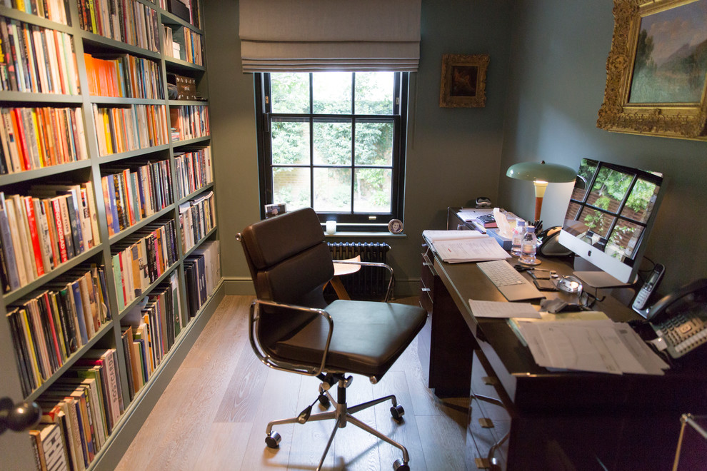 Imagen de despacho tradicional renovado con paredes verdes, suelo de madera oscura y escritorio independiente
