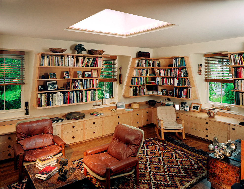 Esempio di uno studio tradizionale di medie dimensioni con libreria, pareti bianche, pavimento in legno massello medio, nessun camino, scrivania incassata e pavimento marrone