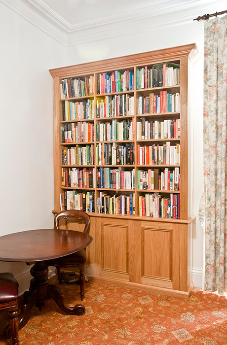 Bild på ett mellanstort vintage arbetsrum, med ett bibliotek, vita väggar, heltäckningsmatta, en standard öppen spis och en spiselkrans i trä