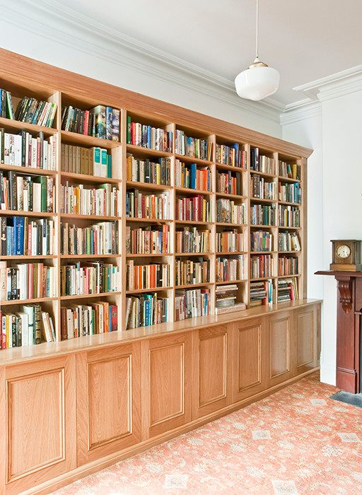 Пример оригинального дизайна: большой домашняя библиотека в классическом стиле с белыми стенами, ковровым покрытием, стандартным камином и фасадом камина из дерева