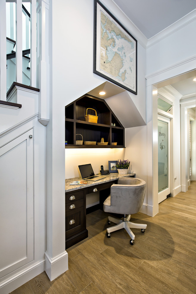 Cette photo montre un petit bureau chic avec un mur blanc, un sol en bois brun et un bureau intégré.