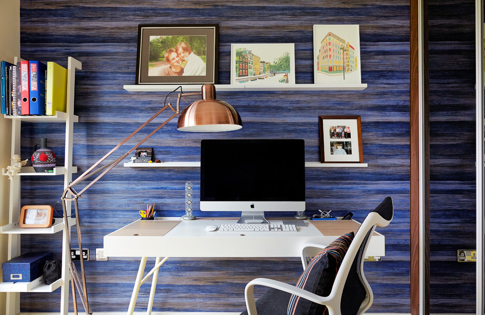 Idéer för små funkis hemmabibliotek, med blå väggar, mörkt trägolv och ett fristående skrivbord