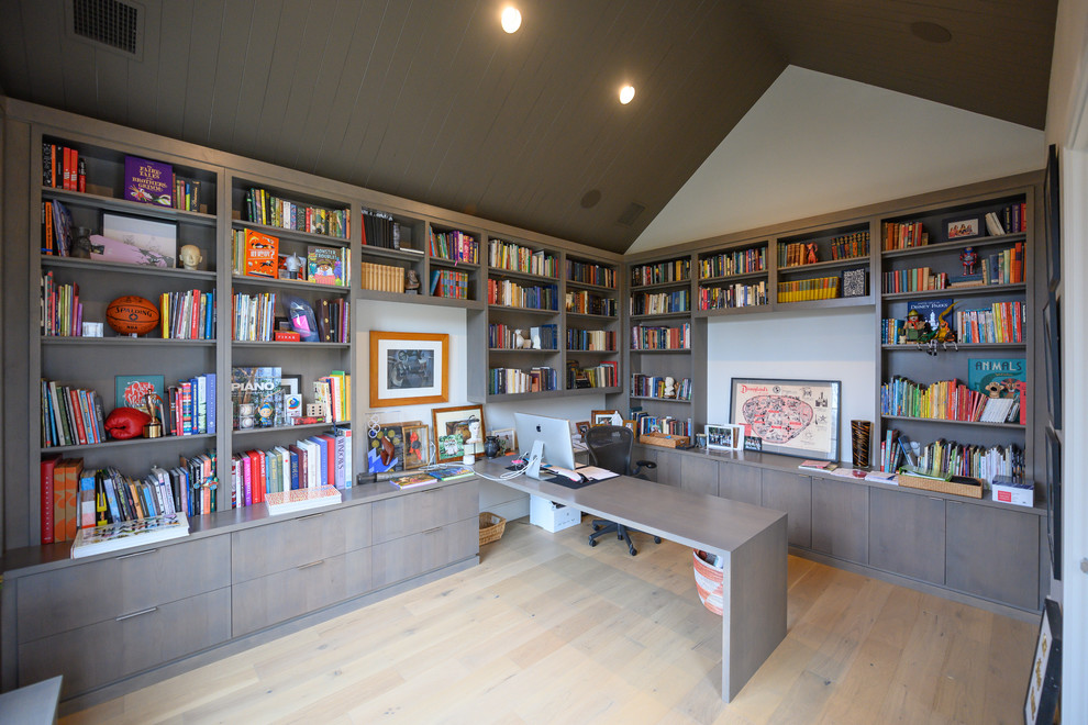 Imagen de despacho campestre con paredes blancas, suelo de madera clara, escritorio independiente y suelo beige