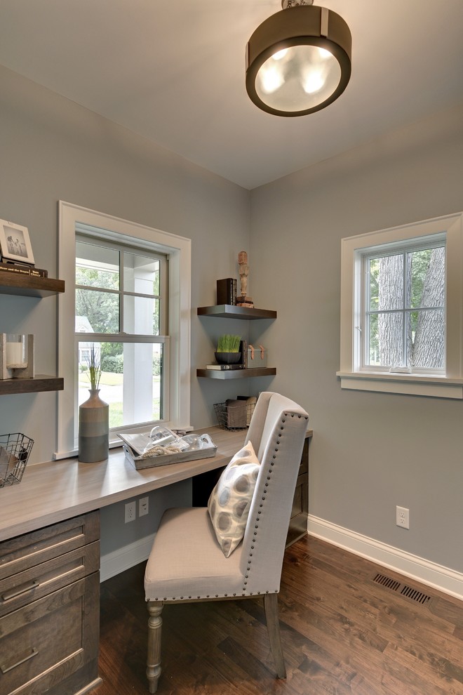 Foto de despacho clásico de tamaño medio sin chimenea con paredes grises, suelo de madera en tonos medios y escritorio empotrado