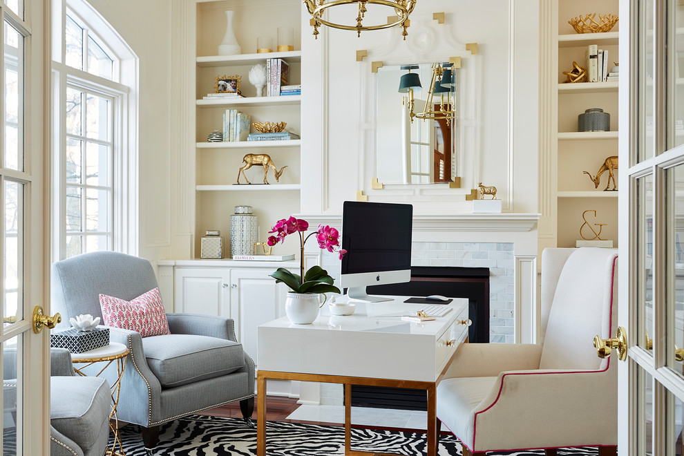 Klassisches Arbeitszimmer mit beiger Wandfarbe, Kamin, freistehendem Schreibtisch, braunem Holzboden, gefliester Kaminumrandung und braunem Boden in Minneapolis