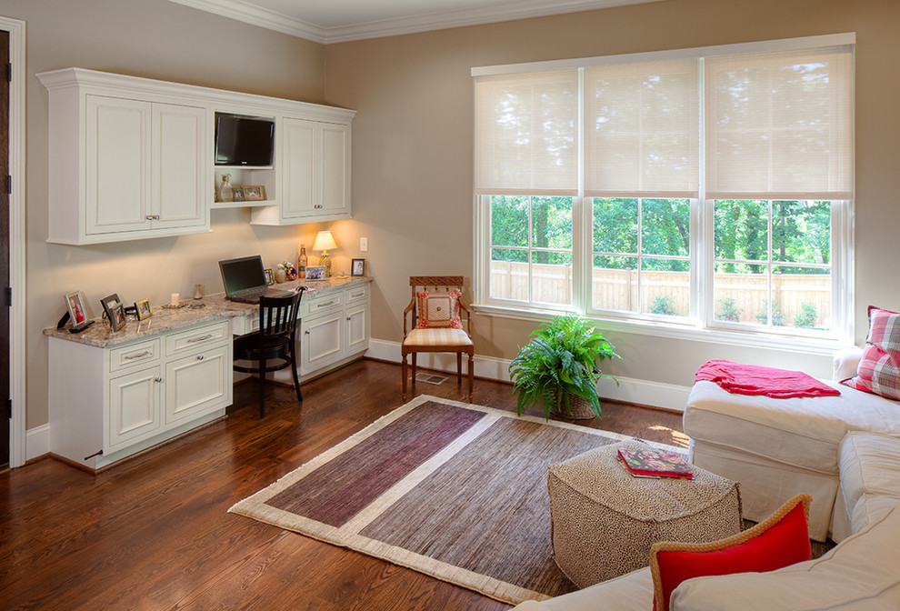 Ejemplo de despacho clásico renovado de tamaño medio sin chimenea con paredes beige, suelo de madera oscura, escritorio empotrado y suelo marrón