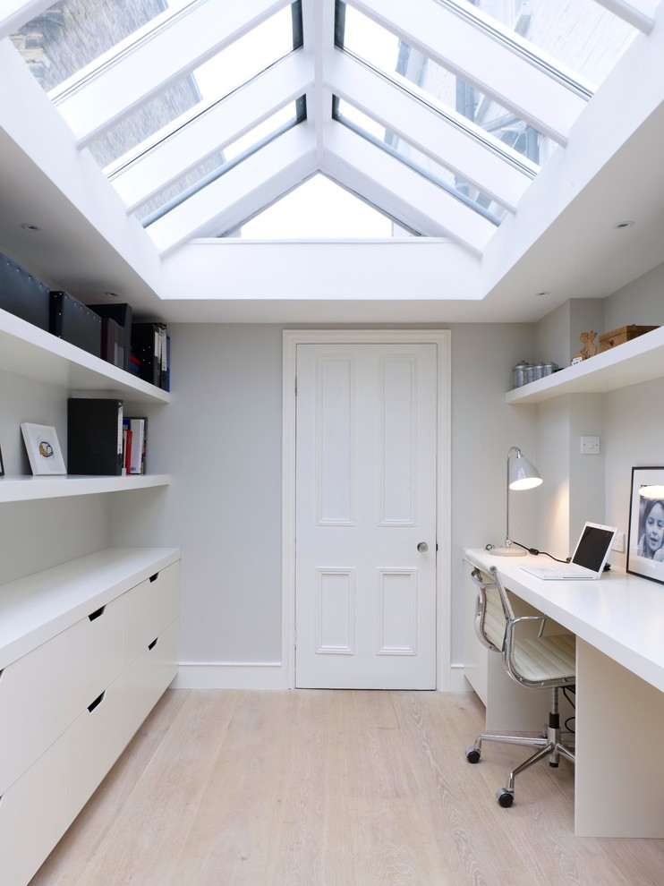 ロンドンにあるコンテンポラリースタイルのおしゃれなホームオフィス・書斎 (白い壁、淡色無垢フローリング、造り付け机) の写真