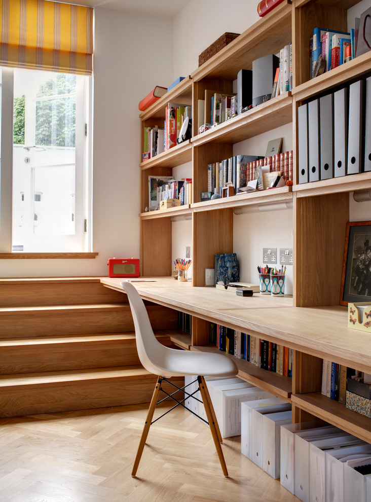 Стильный дизайн: домашняя мастерская в современном стиле с белыми стенами, светлым паркетным полом и встроенным рабочим столом - последний тренд