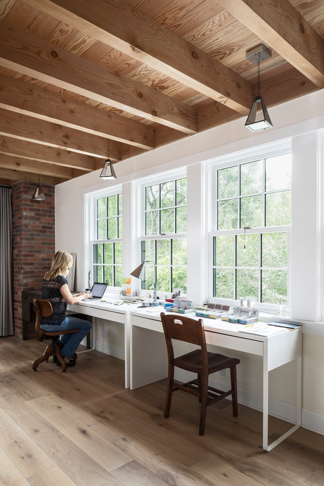 Idéer för ett lantligt hemmastudio, med vita väggar, ljust trägolv, ett fristående skrivbord och beiget golv