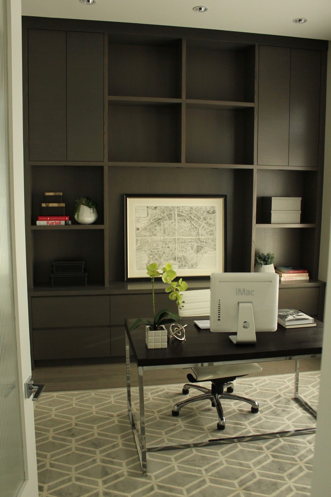 This is an example of a medium sized classic study in Vancouver with laminate floors, a freestanding desk, grey floors and no fireplace.
