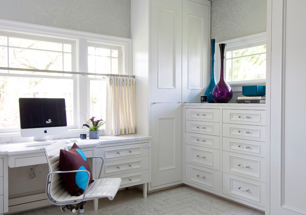 This is an example of a medium sized classic study in Vancouver with marble flooring, white walls, no fireplace, a built-in desk and white floors.