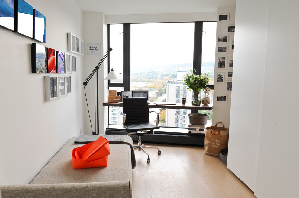 Réalisation d'un bureau minimaliste avec un mur blanc, parquet clair et un bureau intégré.