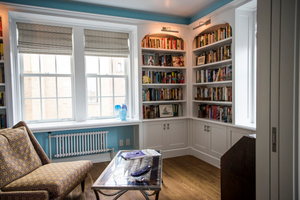 Exemple d'un bureau chic de taille moyenne avec une bibliothèque ou un coin lecture, un sol en bois brun, aucune cheminée, un sol marron et un mur bleu.