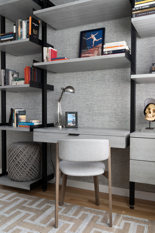 Inspiration för maritima arbetsrum, med ett bibliotek, grå väggar, ljust trägolv och ett inbyggt skrivbord
