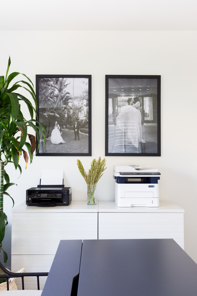 Mittelgroßes Modernes Arbeitszimmer ohne Kamin mit weißer Wandfarbe, braunem Holzboden, freistehendem Schreibtisch und grauem Boden in Los Angeles