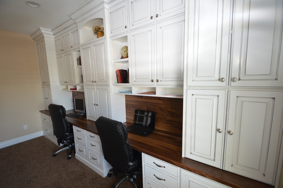 Foto de despacho tradicional de tamaño medio sin chimenea con paredes beige, moqueta, escritorio empotrado y suelo beige