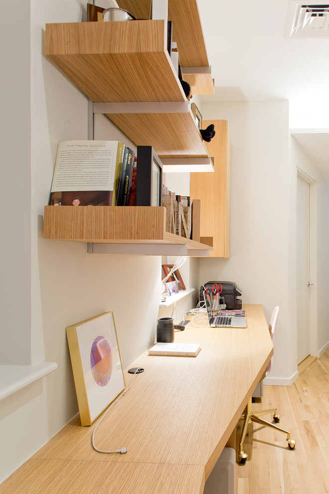 Réalisation d'un bureau design de taille moyenne avec un mur blanc, parquet clair, aucune cheminée, un bureau intégré et un sol marron.