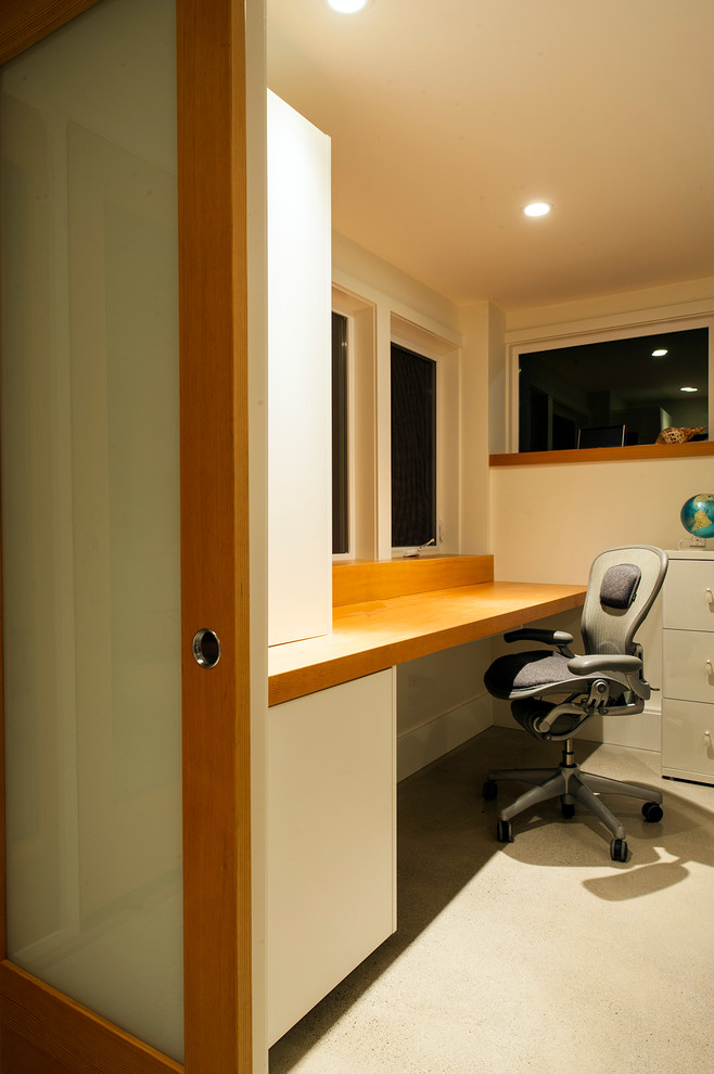 Mid-sized 1960s built-in desk carpeted home office photo in Vancouver with beige walls and no fireplace