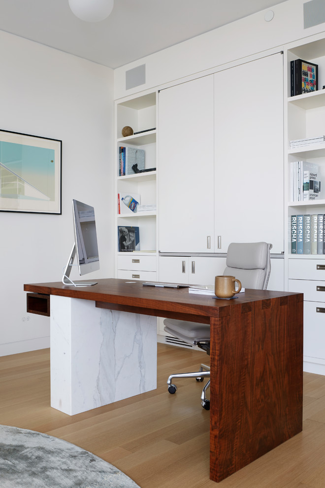 Ejemplo de despacho contemporáneo sin chimenea con paredes blancas, suelo de madera clara, escritorio independiente y suelo beige